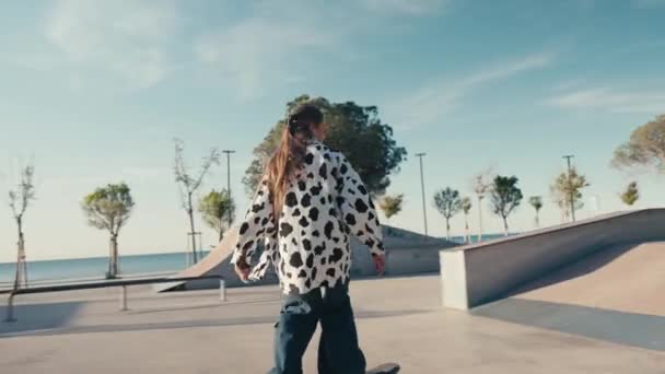 Young woman skateboarding, carving the bowl at the park. Girl rides a skateboarding in a skate park at summer. Tracking shot — Stock videók