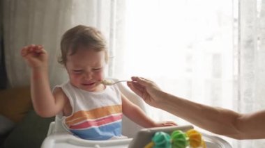 Küçük sarışın çocuk, ona bir ebeveyn verip ağlatacak bir yemek yemek istemiyor.