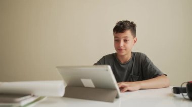 Otantik Çocuk evde arkadaşlarıyla online ödev yapıyor, Çocuk evde öğrenim için tablet kullanıyor, Okul çocuğu öğretmenle online zoom video çalışması yapıyor, E-öğreniyor ya da evde eğitim kavramı geliştiriyor.