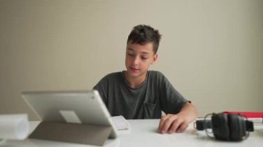 Mutlu Çocuk dersini bitirdi. Evde öğrenim görmek için tablet kullanan çocuk, öğretmenle, e-öğrenimle ya da evde eğitim kavramı ile çevrimiçi zoom videosu eğitimi alan okul çocuğu.