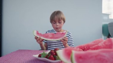 Beyaz çocuk evde karpuz yiyor. Yüksek kalite 4k görüntü