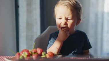 Mutlu çocuk sütle çilek yiyor.