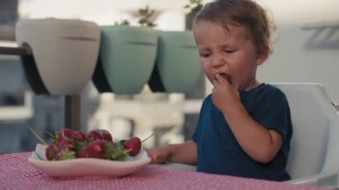 Mutlu çocuk sütle çilek yiyor.