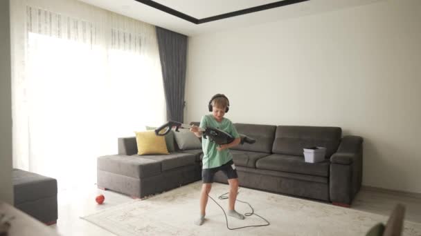 Dziewięciolatek Bawiący Się Podczas Sprzątania Chłopiec Trzyma Odkurzacz Jak Gitarę — Wideo stockowe