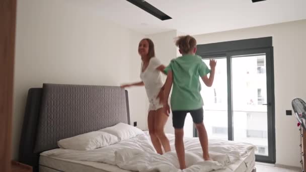 Feliz Mamá Diviértete Saltando Con Pequeño Hijo Cama Movimiento Lento — Vídeos de Stock