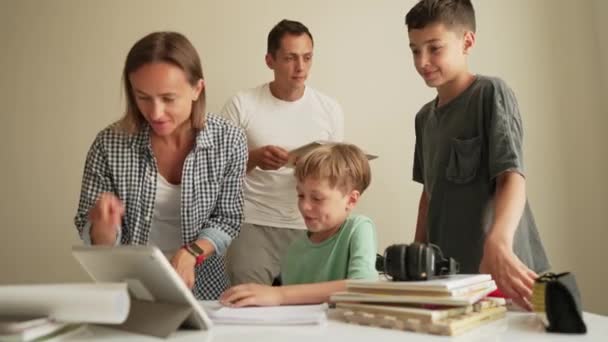 父母和孩子一起做作业 父亲和母亲 还有帮儿子做作业的兄弟 — 图库视频影像