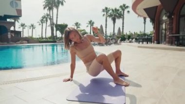 Sportif kadın bir hayvan akışıyla egzersiz yapıyor. Havuzun yakınına taşınıyor.