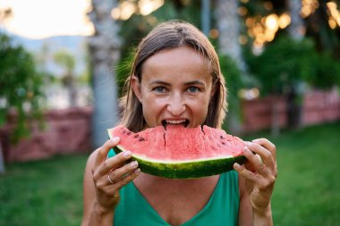 Yazın heyecanlı genç kızın parkta vakit geçirmesi, karpuz ısırması. Yüksek kalite fotoğraf