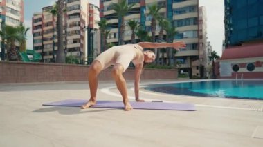 Sportif kadın bir hayvan akışıyla egzersiz yapıyor. Havuzun yakınına taşınıyor.