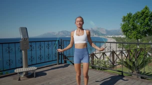 女性は2つのスキップロープでジャンプし ビーチで演習を行います 高品質4K映像 — ストック動画