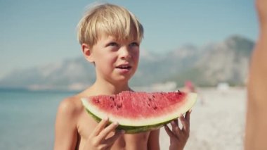  Çocuk sahilde karpuz yiyor, yaz zamanı..