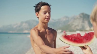  Çocuk sahilde karpuz yiyor, yaz zamanı..