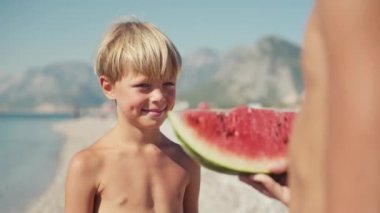 Çocuk sahilde karpuz yiyor, yaz zamanı..
