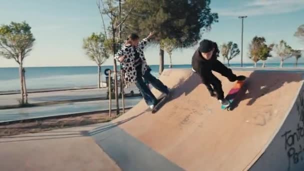 スケートボードに乗って 幸せな男の美しい女性 海辺を歩く若い美しいカップル スケートボード — ストック動画