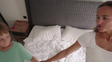 Mutlu anne, oğlunla yatakta zıplarken iyi eğlenceler. Yavaş çekim
