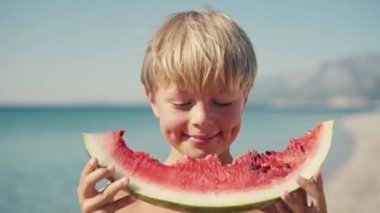  Çocuk sahilde karpuz yiyor, yaz zamanı..