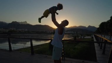 Happy family. Father tosses his son up. Father throws his baby son at sunset. Happy family concept. Father holds baby son in his arms and throws him into sky in sunset time.. High quality 4k footage