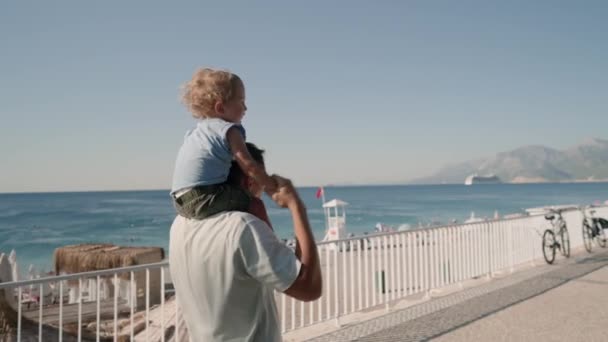 Vader Draagt Zoon Maanden Schouders Loopt Rond Het Strand Gelukkige — Stockvideo
