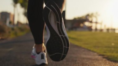 rear view of athletic woman running on seaside at summer. High quality 4k footage