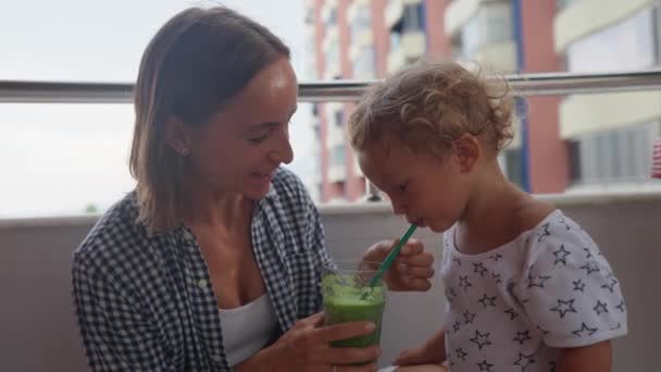 Caucasian Baby Sitting Kitchen Table Green Leaves Drinking Green Smoothie — Vídeo de stock