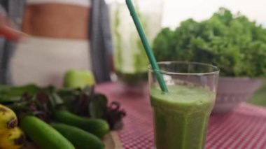 Young smiling woman drinking detox smoothie through straw. Happy vegetarian drinks fresh green vegetable cocktail. Weight Loss, slimming Concept. Healthy eating habits. High quality 4k footage