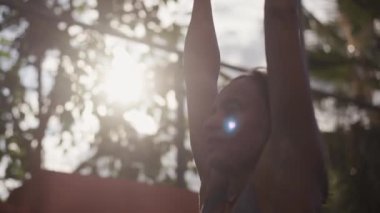 Healthy woman training gymnastics exercise using rings enjoying intense fitness workout. Caucasian sportswoman doing pull ups at street workout place. High quality 4k footage
