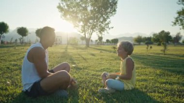 family, leisure and people concept - happy father juggling apples and son learning. Father and son having picnic at summer park. High quality 4k footage
