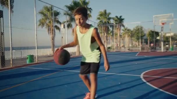 Chlapec Odpaluje Basketbal Trénuje Hřišti Dívá Kamery Kluk Trénuje Basketbal — Stock video