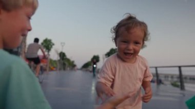 A young boy runs while laughing out loud. The happy toddler is having a wonderful time running outdoors in the waterfront park.