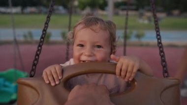 Little boy having fun on chain swing. The simple joys of childhood
