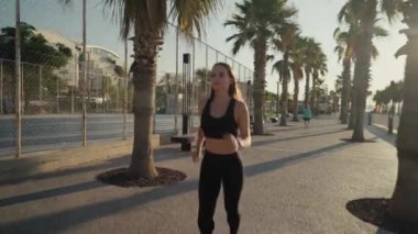 Young active woman jogging along beautiful beach. Running happy woman enjoying their summer morning workout. High quality 4k footage