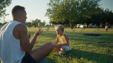 family, leisure and people concept - happy father juggling apples and son learning. Father and son having picnic at summer park. High quality 4k footage