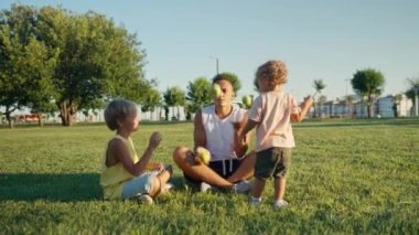 Happy father juggling with green apples in the park with his kids. High quality 4k footage