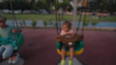 Little boy having fun on chain swing. The simple joys of childhood