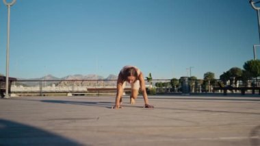 Young woman doing exercise outdoor animal flow innovative movement. Young caucasian woman doing workout at sunrise