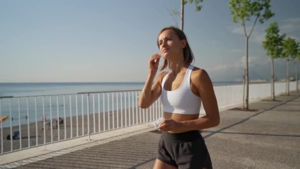 女运动员在日落时跑步 用耳机听音乐 运动音乐 放弃你的目标是没有意义的 — 图库视频影像