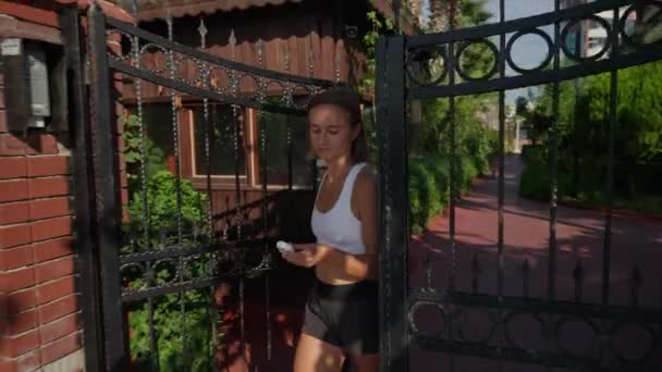 Całkiem Wysportowana Młoda Kobieta Sportowych Ciuchach Wychodzi Pobiegać Domu Zakłada — Wideo stockowe