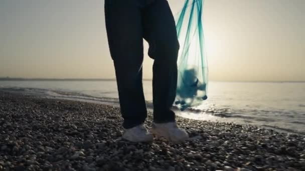 여성이 버려진 플라스틱 병들을 해변에서 있습니다 해변에서 쓰레기를 모으는 여자들 — 비디오