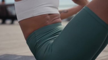 Sportif formda genç bir kadın bisiklet çatırdatma egzersizi yapıyor, tahta zeminde yatıyor, güçlü bir sporcu kadın aktif giysi giyiyor, karın kaslarını çalıştırıyor..