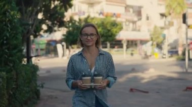 Paket kahve. Kadın elleri şehir parkında iki bardak sıcak kahve tutuyor..