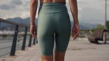 Deniz kıyısında birlikte yürüyen sağlıklı ve formda bir kadın. Eğitimden sonra yaz doğasının tadını çıkaran genç bir kadın. Etkin yaşam biçimleri kavramı