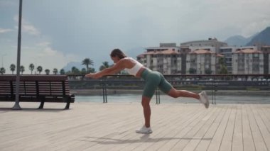 Genç kadın denge egzersizi yapıyor ve spor yogası, spor çorapları ve top, güneşli bir günde açık havada. Yüksek kalite 4k görüntü