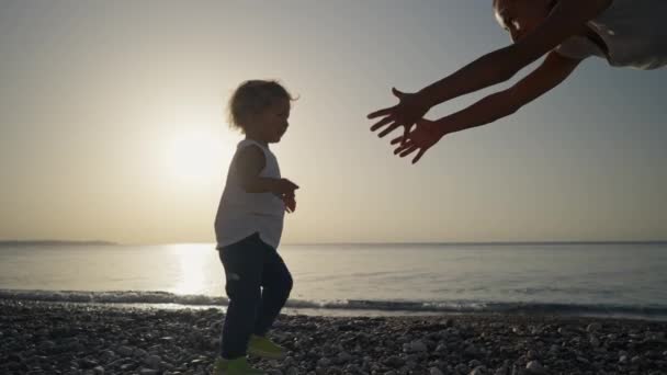 母亲节快乐 美丽的母亲和婴儿在海滩上玩耍 妈妈和她的孩子一起享受日落 爱你的单身母亲拥抱着可爱的小儿子 — 图库视频影像
