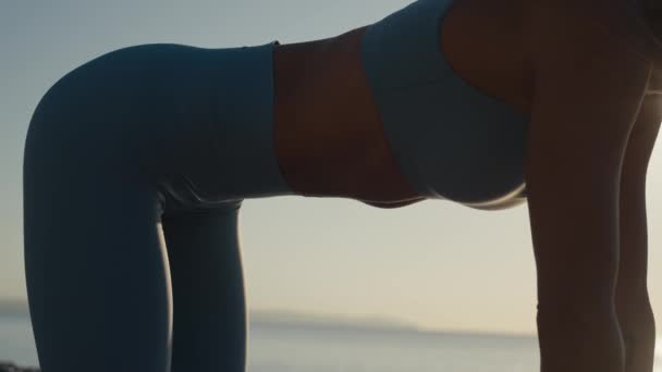 海で午前中に腹部の筋肉のための真空運動を作るフィット女性 — ストック動画