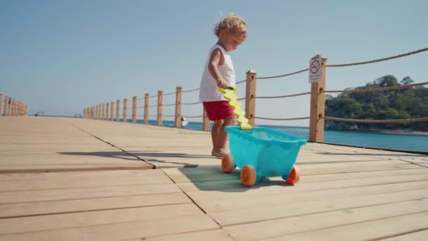 Ein Kleiner Junge Spielt Barfuß Meer Auf Einer Holzbrücke Sommerzeit — Stockvideo