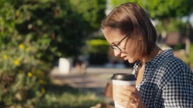 tablet ve paket servisi olan restoran kahve ile parkta genç kadın.