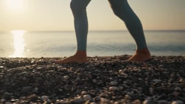 Bir Kadın Gün Doğumunda Çakıl Taşları Üzerinde Deniz Kıyısında Yürür — Stok video