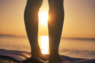 Siluet genç kadın gün batımında plajda yoga yapıyor. Yüksek kalite fotoğraf