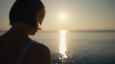 Kadın, plajda yoga pozunda meditasyon yapıyor. Yoga konsepti. El kadını sahilde nilüfer poz pratiği yapıyor.