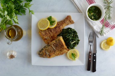 Sauteed Ispanak ve Beyaz Tabakta Kızarmış Balık 